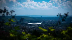 Blick auf die MHP Arena in Stuttgart umgeben von herbstlicher Natur und Stadtlandschaft.