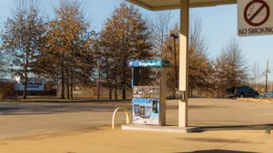 Eine moderne Tankstelle in einer herbstlichen Umgebung bei klarem Tageslicht.